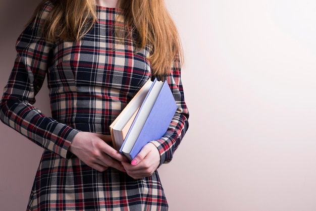 Foto gratuita la ragazza con i capelli lunghi azienda alcuni libri