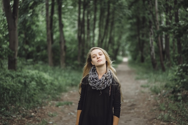 girl with long hair walks through the forest.