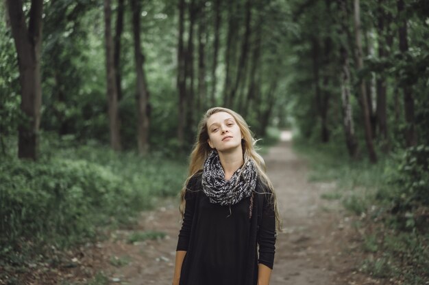 girl with long hair walks through the forest.