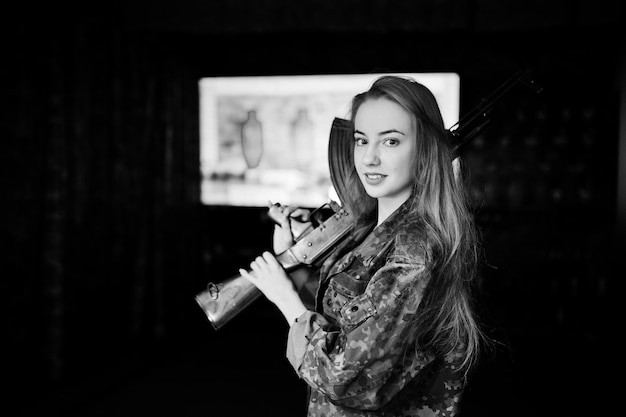 Девушка с автоматом в руках на стрельбище