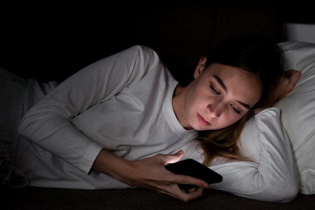 Girl with mobile in bed
