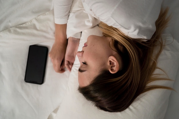 Free photo girl with mobile while sleeping