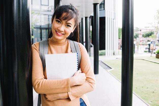 Free photo girl with notebook smiling at camera