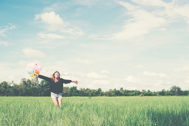 Ragazza con le braccia aperte e palloncini