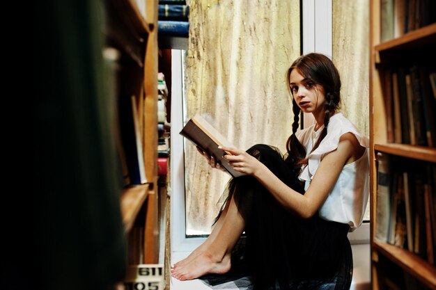 Girl with pigtails in white blouse at old library