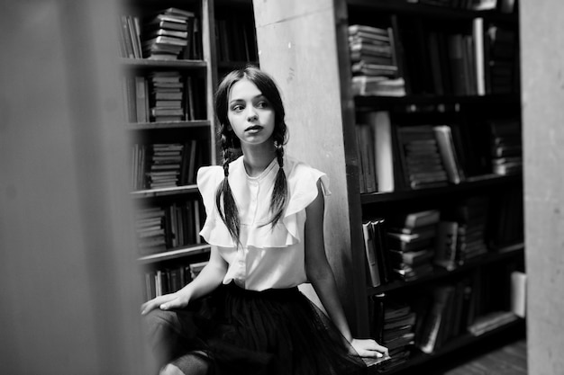 Free photo girl with pigtails in white blouse at old library