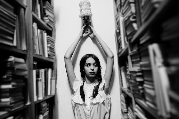 Girl with pigtails in white blouse at old library