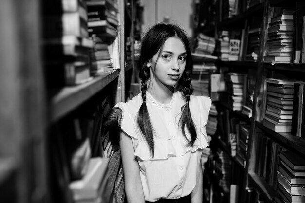 Girl with pigtails in white blouse at old library