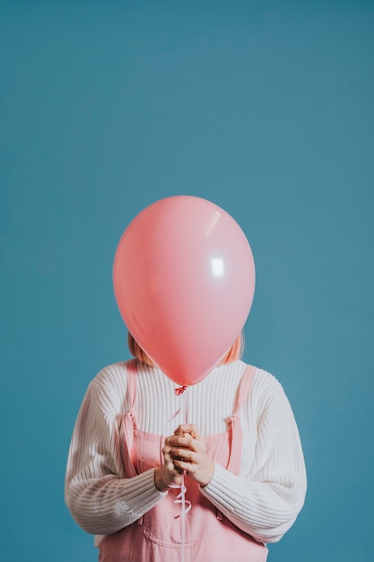 Ragazza con un palloncino rosa ad elio