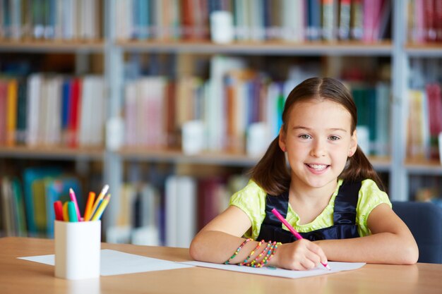 Girl with pink pencil in the library