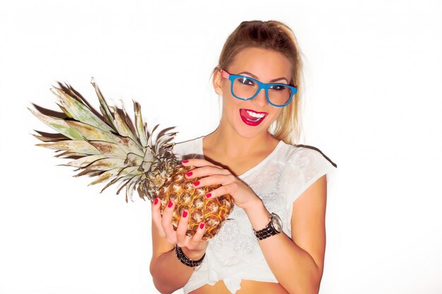 Girl with red lips holding a pineapple