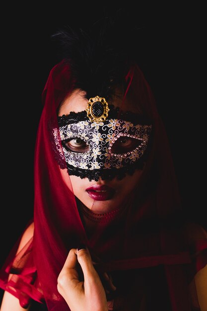 Girl with a red scarf on her head and a venetian mask