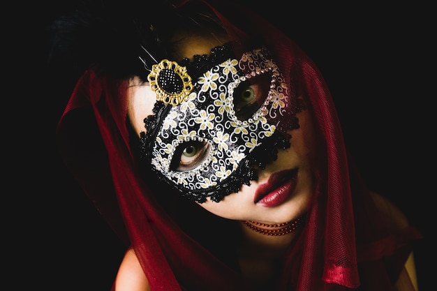 Free photo girl with a red scarf on her head and a venetian mask