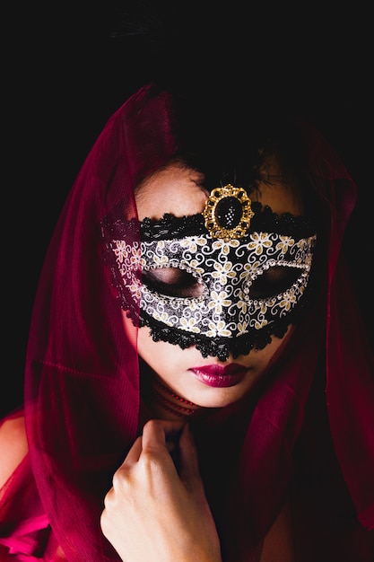 Девушка с красным шарфом на голове и венецианские маски