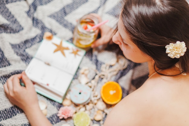 Ragazza con bibita rinfrescante consulta la sua agenda