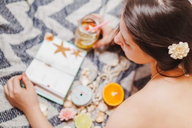 Girl with refreshing drink consulting her agenda