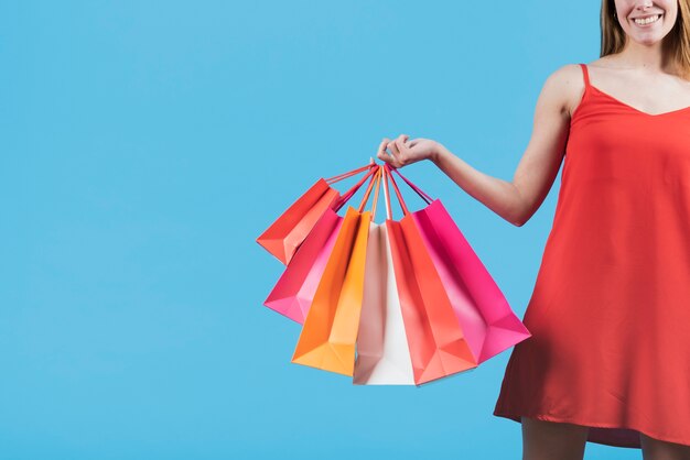 Girl with shopping bags on plain background