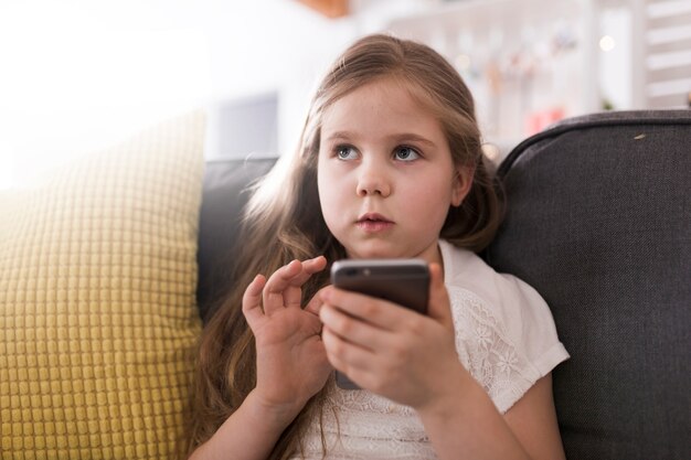 Girl with smartphone on couch