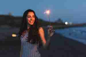 Foto gratuita ragazza con sparkler in spiaggia