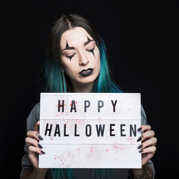 Girl with spooky makeup holding signboard