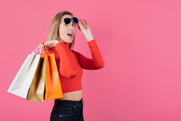 Girl with sunglasses holding shopping bags