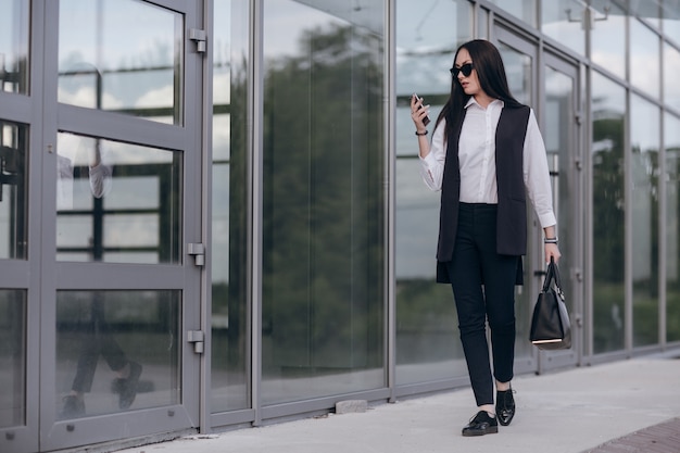 Girl with sunglasses looking at her smartphone