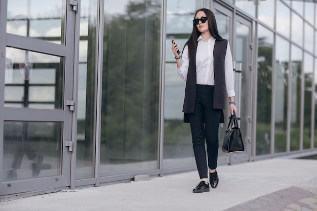 Girl with sunglasses looking at her smartphone