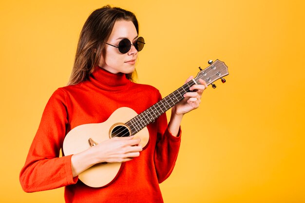 Girl with sunglasses playing the ukelele