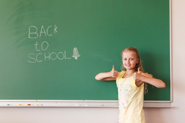 Girl with thumbs up in classroom