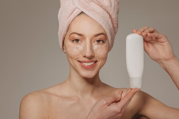 Girl with towel on the head showing cream