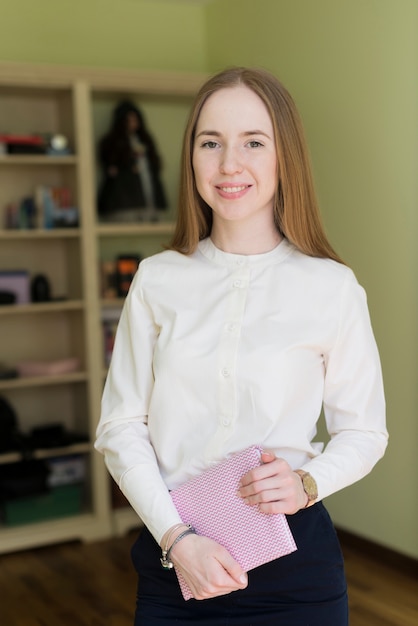 Ragazza con la camicia bianca in possesso di un notebook