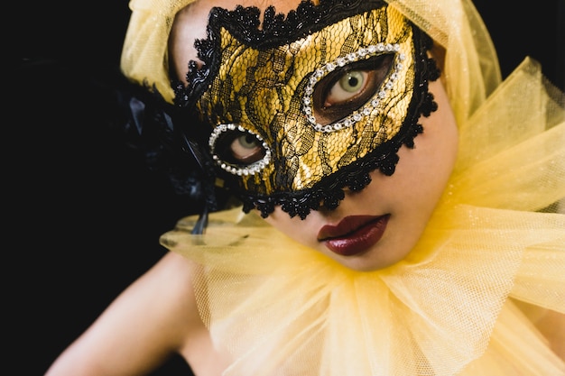 Girl with a yellow ornament on her head and a venetian mask