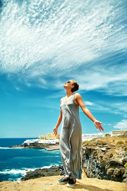 girl woman in casual hipster clothes standing on the cliff of mountain