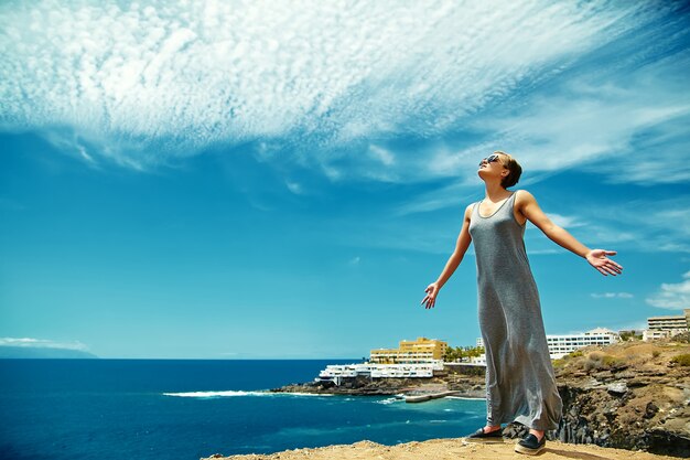 girl woman in casual hipster clothes standing on the cliff of mountain