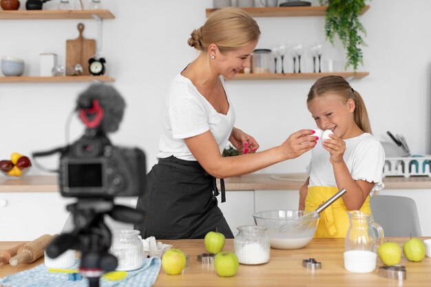 Girl and woman holding eggs medium shot