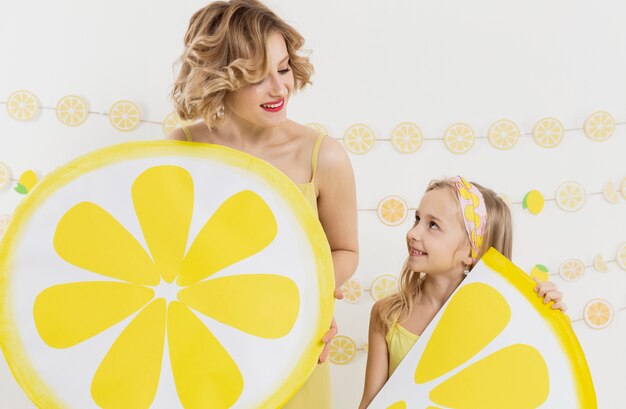 Girl and woman holding lemon slices decorations