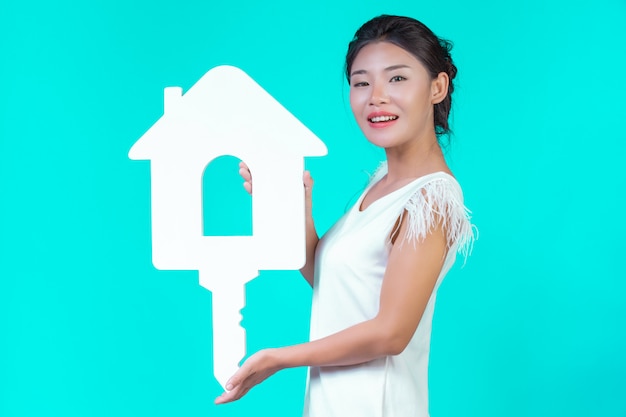 The girl wore a white long-sleeved shirt with floral pattern, holding the house symbol and showing various gestures with a blue .