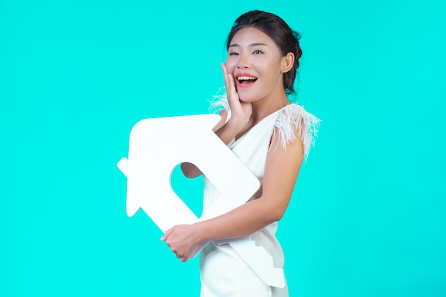 The girl wore a white long-sleeved shirt with floral pattern, holding the house symbol and showing various gestures with a blue .