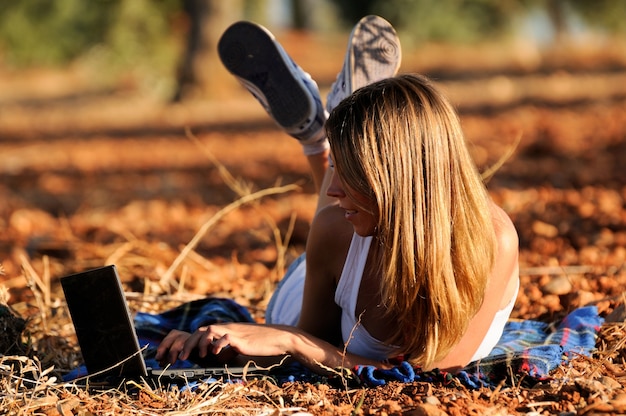 Girl working with her laptop lying on the ground