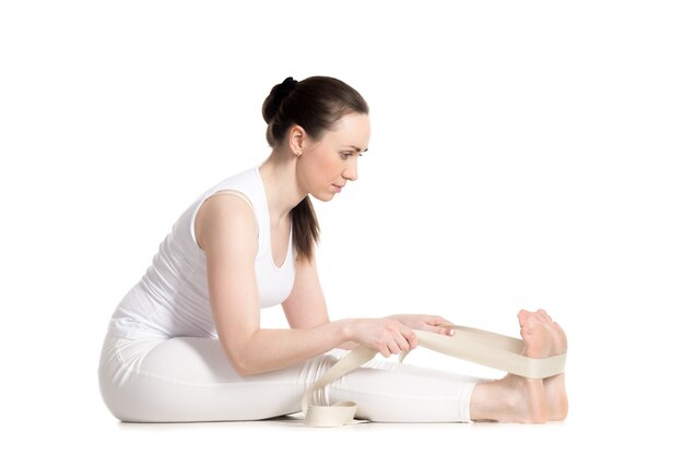 Girl working in yoga class with a strap