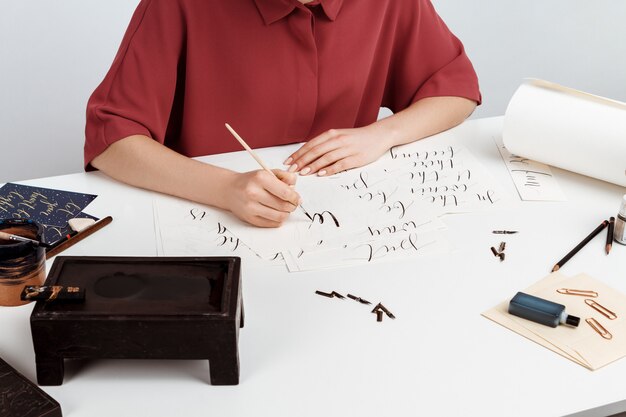 Girl writing calligraphy on postcards. Art design.