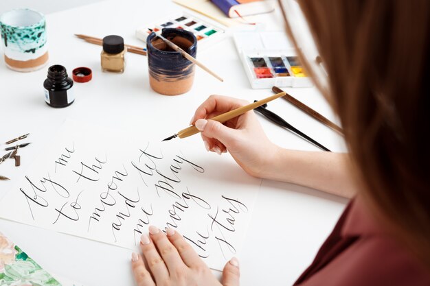 Girl writing calligraphy on postcards. Art design.