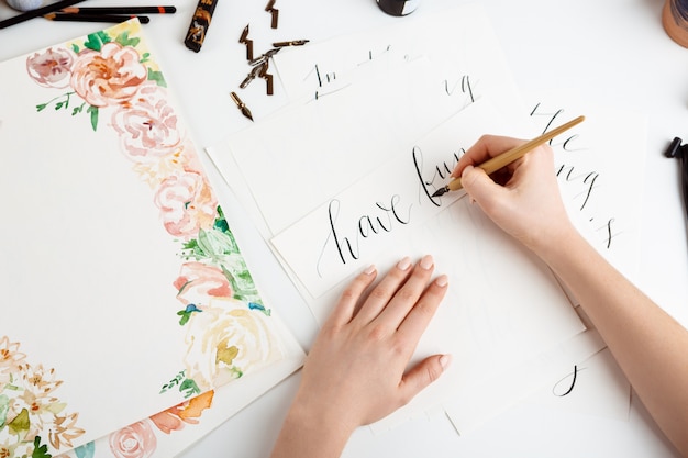 Girl writing calligraphy on postcards. Art design.