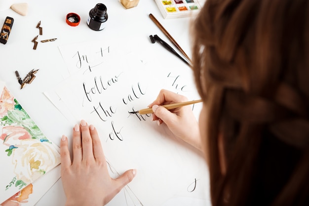 Girl writing calligraphy on postcards. Art design.