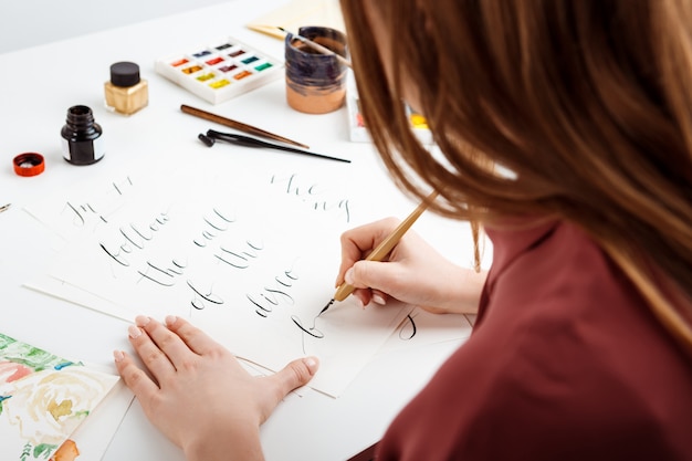 Girl writing calligraphy on postcards. Art design.