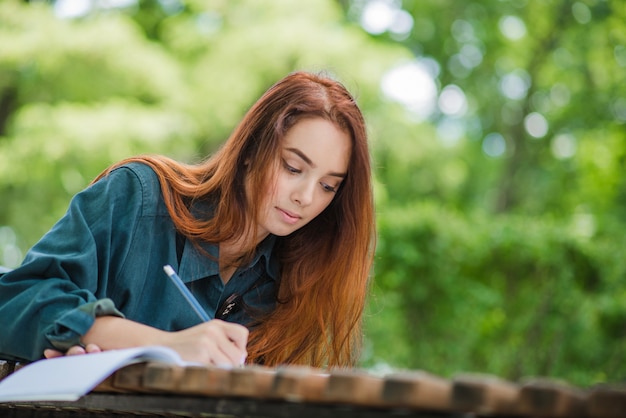 Girl writing in notebook on table