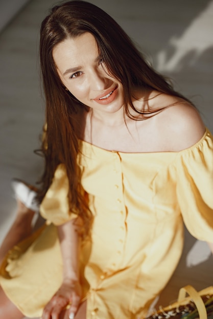 Girl in a yellow dress with a basket in her hands celebrates easter