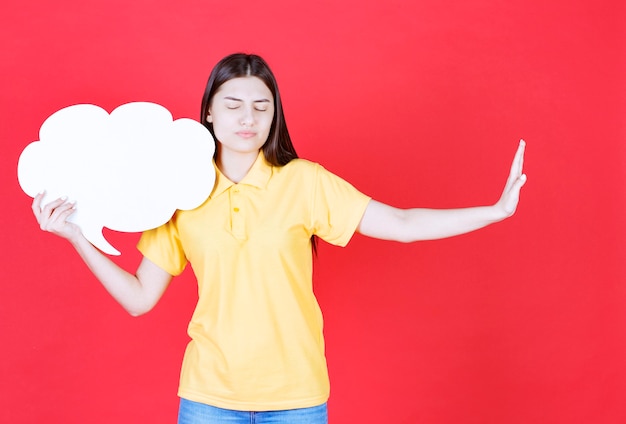 Girl in yellow dresscode holding a cloud shape info board and stopping something.