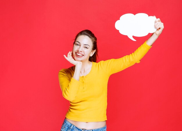 Girl in yellow shirt holding a cloud shape info board.