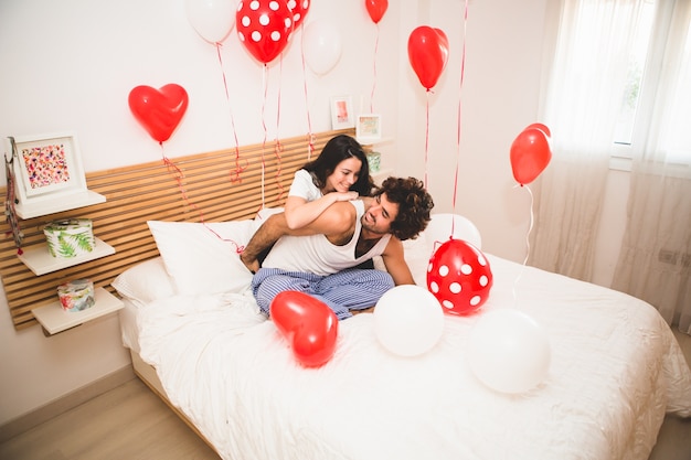 Free photo girlfriend climbing her boyfriend's back on the bed